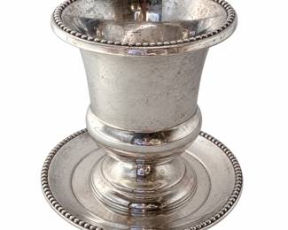 International Silver Co. sterling silver footed urn-form cup with matching underplate, featuring classic beaded borders, a flared rim, rounded lower body, and raised pedestal foot. The underside is clearly marked “INTERNATIONAL STERLING 103 96” with the International Silver hallmark. The coordinating round underplate repeats the beaded-edge design for an elegant matched presentation. Approximately three inches tall as shown beside ruler; please review photographs for exact dimensions. Vintage sterling silver shows visible tarnish, surface wear, spotting, scratches, and other signs of age and use; the interior shows notable tarnish/discoloration and surface wear. Offered in its existing, unpolished condition. An attractive piece of American sterling silver hollowware for collectors, table service, display, or a traditional silver collection. Please review all photographs carefully as they are part of the condition description. Dimensions 3" Tall