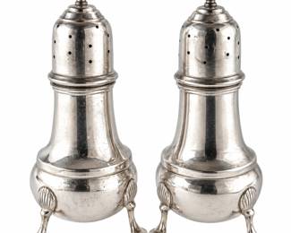 Description Vintage silver salt and pepper shaker set featuring classic baluster-form bodies, pierced domed tops with decorative finials, and elegant tripod bases with shell-form accents and scrolling feet. The traditional silhouette and refined silver finish give this matched pair a timeless formal table setting appeal. An attractive addition to a collection of antique and vintage silver, dining accessories, hollowware, or decorative tableware. Both pieces show age-appropriate surface wear and patina consistent with use. Please review all photographs carefully for hallmarks, silver content, maker, measurements, and condition, as photographs are considered part of the description. Dimensions 4 1/2" - 5" Tall