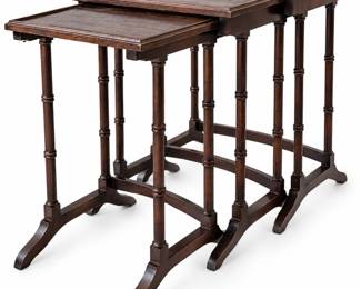 Attractive set of three graduated nesting tables featuring a rich dark mahogany-tone finish, rectangular tray-style tops with raised molded edges, slender turned legs, curved stretchers, and gracefully shaped feet. The three tables nest together for compact storage and can be separated for use as occasional, side, or drink tables. Traditional styling and warm wood tones make this a versatile set for a variety of interiors. Vintage/pre-owned condition with visible age and use, including scratches, finish wear, rubbing, spotting, and surface variation, particularly to the tabletops and edges, as shown in the photographs. Exact maker, age, and wood species have not been independently identified. Please review all photographs carefully for construction and condition. Set includes three nesting tables.