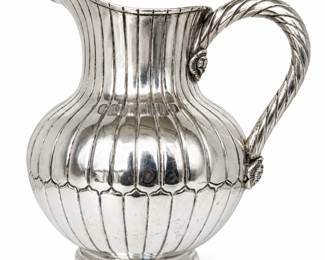 Striking vintage sterling silver water pitcher by Sanborns of Mexico, featuring a deeply fluted bulbous body, elegant flared pouring spout, substantial twisted rope-form handle, and applied floral rosette accents at the handle mounts. The pitcher rests on a stepped circular foot and displays the distinctive craftsmanship associated with Mexican sterling silver hollowware. Underside is clearly hallmarked with the Sanborns owl logo, “SANBORNS MEXICO STERLING.” Surface shows age-appropriate scratches, tarnish, patina, and signs of use; these have been intentionally left visible and the piece has not been refinished for photography. Please review all photographs for condition and hallmark details. An impressive piece of vintage Mexican sterling suitable for use, display, or a silver collection.