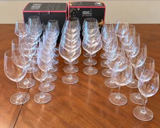 Impressive collection of Riedel crystal wine glasses featuring an assortment of stemware designed for different wine and beverage styles. The collection includes a variety of bowl shapes and sizes, including larger red wine glasses, traditional wine glasses, slender white wine forms, and champagne-style stemware. Several pieces retain the etched Riedel signature on the foot, and Riedel storage/retail boxes are included as shown. An excellent opportunity to acquire a substantial collection from one of the best-known names in premium wine glassware. Offered together as one collection. Pre-owned condition with light signs of use consistent with normal handling and storage. Please review photographs for exact quantities, styles, and condition.