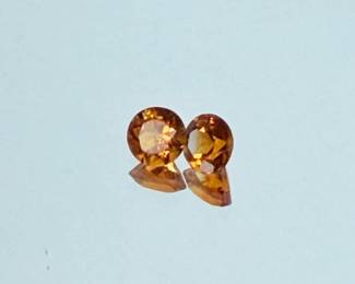Pair of loose round-cut citrine gemstones featuring warm golden-orange color and faceted cuts. The two stones have a combined total weight of approximately 0.82 carats. Offered together as a matched pair, suitable for earrings, custom jewelry design, collecting, or resetting. Please review all photographs for color, cut, proportions, measurements, and overall condition. Gemstone identification and weight are based on information provided with the collection; stones have not been independently laboratory certified unless otherwise stated.
