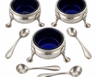Charming vintage seven-piece sterling silver salt cellar set featuring three individual footed open salts accompanied by four sterling silver salt spoons. Each round cellar is raised on three decorative shell-form feet and displays a classic traditional design with an elegant rolled rim. The cellars are marked “B & M STERLING 43” and retain their original vintage finish with age-appropriate surface wear and patina. Four assorted sterling salt spoons complete the collection. A beautiful addition to a sterling silver tableware, hollowware or dining collection and ideal for entertaining, holiday table settings or display. Please review all photographs for design, measurements, markings and condition; ruler shown for scale.