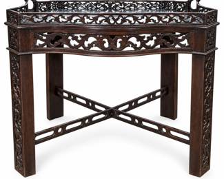Distinctive antique-style wooden tray table featuring extensive pierced and carved decoration throughout. The shaped serpentine tray top is fitted with a glass insert and surrounded by an ornate openwork gallery with integrated handles at each end. The coordinating base features a pierced serpentine apron, decorative cutwork along the legs, and crossed X-form stretchers with geometric openings. Dark stained wood finish gives the piece a dramatic decorative presence suitable as a serving table, occasional table, tea table, or accent piece. Vintage condition with surface wear, scratches, finish variation, and areas of wear and loss to the lower stretchers as shown in the photographs. Glass shows surface scratching consistent with previous use. Maker, exact age, wood species, and country of origin have not been independently identified. Please review all photographs carefully for construction, condition, and details. Sold as pictured.