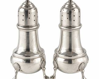 Vintage silver salt and pepper shaker set featuring classic baluster-form bodies, pierced domed tops with decorative finials, and elegant tripod bases with shell-form accents and scrolling feet. The traditional silhouette and refined silver finish give this matched pair a timeless formal table setting appeal. An attractive addition to a collection of antique and vintage silver, dining accessories, hollowware, or decorative tableware. Both pieces show age-appropriate surface wear and patina consistent with use. Please review all photographs carefully for hallmarks, silver content, maker, measurements, and condition, as photographs are considered part of the description. Dimensions 4 1/2" - 5" Tall