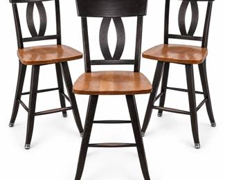 Set of three coordinating counter/bar stools featuring warm natural-finish wood seats contrasted by dark espresso-finished frames. Each stool has a gently curved upper back with a distinctive open oval-form decorative splat, shaped wood seat, splayed legs, footrest stretchers, and metal-tone foot caps. Seat height measures approximately 30 inches, making these suitable for bar-height seating. Pre-owned condition with visible scratches, finish wear, scuffs, and other signs of age and regular use, particularly to the dark-finished backs and frames. Please review all photographs carefully for construction, finish, and condition. Maker and wood species have not been independently identified. Sold as a set of three.