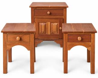 Coordinating set of three solid cherry wood accent tables featuring warm natural cherry tones and traditional styling. The set includes two single-drawer end/side tables with straight legs and shaped aprons, along with a larger cabinet-style nightstand featuring a single upper drawer, paneled cabinet door, wood knobs, and bracket-style base. The tables display attractive natural wood grain and traditional joinery details, with the tops showing contrasting grain patterns and visible wood plugs. Functional drawers provide convenient storage. Pre-owned condition with scratches, scuffs, finish wear, spotting, and other surface marks consistent with use, particularly to the tops; please review photographs carefully for condition. A versatile matching set for bedroom, living room, or family room use. Sold together as a set of three.