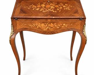 Elegant antique French Louis XV style slant-front writing desk featuring extensive floral marquetry and contrasting geometric veneer throughout the fall front, apron and side panels. The shaped fall front opens to reveal a writing surface with decorative border and a fitted interior with three small drawers and open storage compartment. The desk is raised on graceful cabriole legs accented with ornate brass-tone mounts and feet, while a pierced brass-tone gallery surrounds the upper edge. Detailed floral and ribbon marquetry provides exceptional visual interest from multiple angles. Antique condition with age-related surface wear, scratches, veneer losses and lifting, edge wear, finish variation and evidence of previous repairs, as shown in the photographs. Exact age, maker, country of manufacture and wood species have not been independently authenticated. Please review all photographs carefully for construction, condition and decorative details. Sold as photographed.