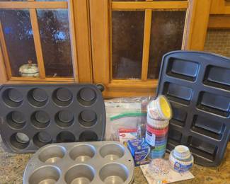 Title: Baking & Cake Decorating Collection – Wilton Pans, Muffin Tins, Baking Cups & Supplies Description: Assorted baking and cake decorating collection featuring Wilton and other bakeware, including muffin/cupcake pans, rectangular baking molds, assorted paper baking cups and liners, Reynolds designer baking cups, birthday candles, storage bags, and additional baking accessories. A useful grouping for home bakers, cake decorators, holiday baking, parties, and entertaining. Items show typical signs of household use; please review photos for included contents and condition.