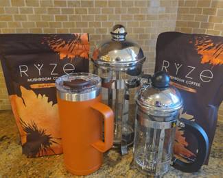 Coffee Lover’s Collection – French Presses, Ryze Mushroom Coffee & Insulated Mug Description: Coffee and beverage collection featuring two glass-and-stainless French press coffee makers in different sizes, an insulated handled travel mug with lid, and two bags of Ryze Mushroom Coffee. Great for coffee lovers, home beverage bars, morning routines, travel, or entertaining. French presses feature classic plunger-style construction with metal frames and glass carafes. Please review photo for exact contents, condition, and product dates where applicable.