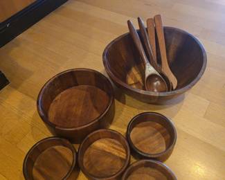 Title: Vintage Wood Salad Bowl Set with Serving Utensils Description: Classic wood salad serving collection featuring one large salad bowl, five individual bowls, and four coordinating wooden serving utensils. Warm wood grain and a traditional mid-century-inspired look make this a great set for entertaining, farmhouse décor, cabin décor, or everyday dining. Shows normal signs of age and use consistent with vintage kitchenware; please review photo for condition and included pieces.