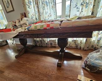 Beautiful carved wood table under the quilts