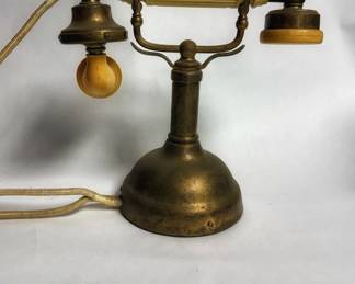 Vintage French-style or candlestick-style decorative desk telephone with a brass-finished metal body and a cream-colored Bakelite handle.