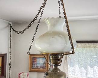 Vintage hanging oil-style swag lamp with a white milk glass shade and brass-toned hardware, popular in mid-20th-century and 1970s home decor.