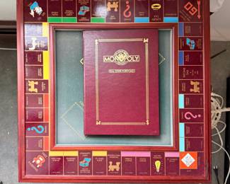 1991 Franklin Mint Monopoly Collector's Edition board game, featuring a wooden frame, a green playing surface, and a matching red real estate portfolio storage book in the center.