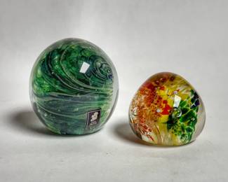 A hand-blown green swirl art glass paperweight made by Kerry Glass in Ireland and vintage studio art glass paperweight featuring an ice-pick / trumpet flower design