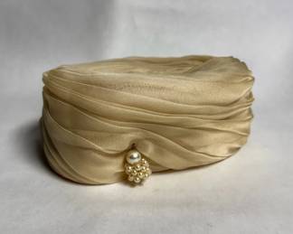 Vintage-style draped champagne pleated turban hat adorned with a small cluster of faux pearls.