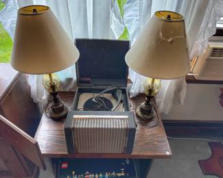 Vintage table lamps featuring an amber glass accent paired with a classic conical shade as well as a vintage Webcor portable suitcase record player.