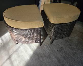 Two outdoor wicker ottomans with cushions