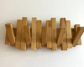 Retractable coat racks with vertical wooden slats that fold down into individual hooks when needed