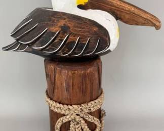 Carved wooden pelican sitting on a piling