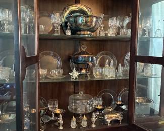 Glass cabinet filled with crystal and silver items