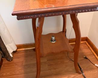 Antique oak parlor table with carved rim and lower shelf