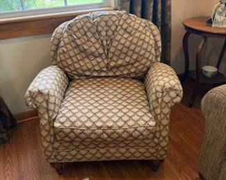 Upholstered armchair with rolled arms in patterned fabric