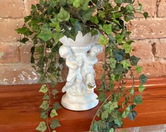 White ceramic cherub vase with faux ivy arrangement