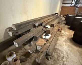 Stack of large weathered wood beams with size markings