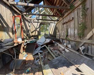 Dilapidated wooden shed interior full of salvage and scrap metal