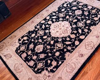 Floral wool area rug in black and beige