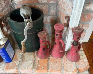 Vintage green wooden ice cream churn with hand crank, cast iron jacks nearby
