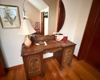 Antique vanity desk with round wall mirror and carved details