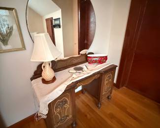 Antique wood vanity with round mirror and inlay detail