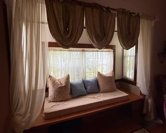 Built-in wood window seat with cushion and throw pillows