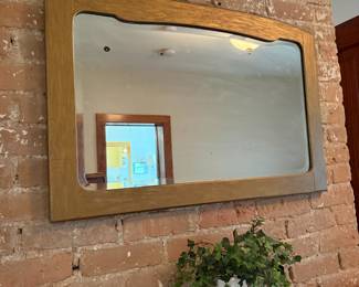 Wood framed rectangular wall mirror with curved top corners