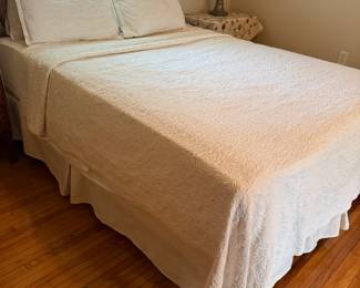 Queen bed with white matelasse coverlet and shams