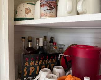 Cabinet lot with mugs, liquor bottles, and juicer