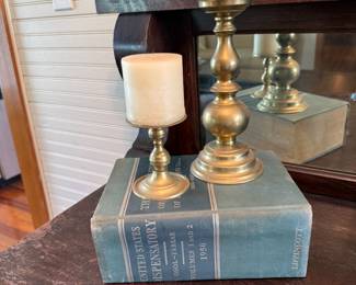 Brass candlestick pair with pillar candles on 1950 dispensatory book
