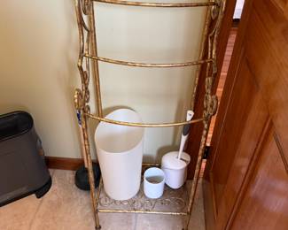 Gold scrolled metal towel rack with four bars and base shelf