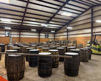 Warehouse full of large wooden whiskey barrels