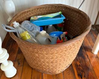 Woven wicker basket filled with assorted cleaning supplies
