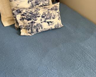 Blue toile farmhouse pillows with quilted paisley bedspread