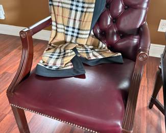 Burgundy tufted leather armchair with nailhead trim and carved arms