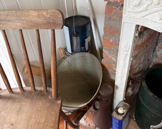 Vintage galvanized wash basin beside exposed brick fireplace surround