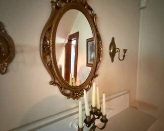 Ornate gold gilt oval wall mirror with floral scrollwork frame