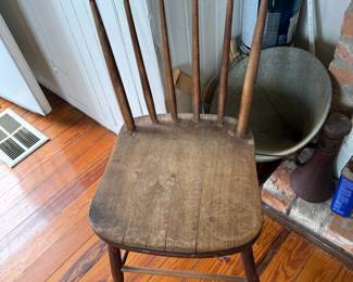 Primitive wooden spindle back chair with worn plank seat