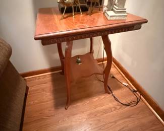 Carved wood side table with curved legs and lower shelf
