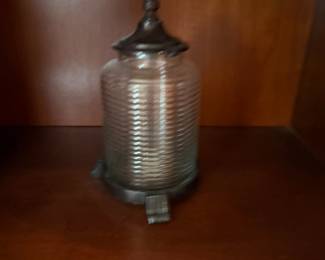 Ribbed glass jar with ornate metal lid and footed base